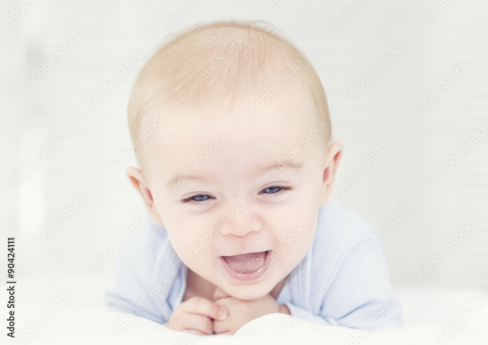 Adorable smiling baby lying in the bed