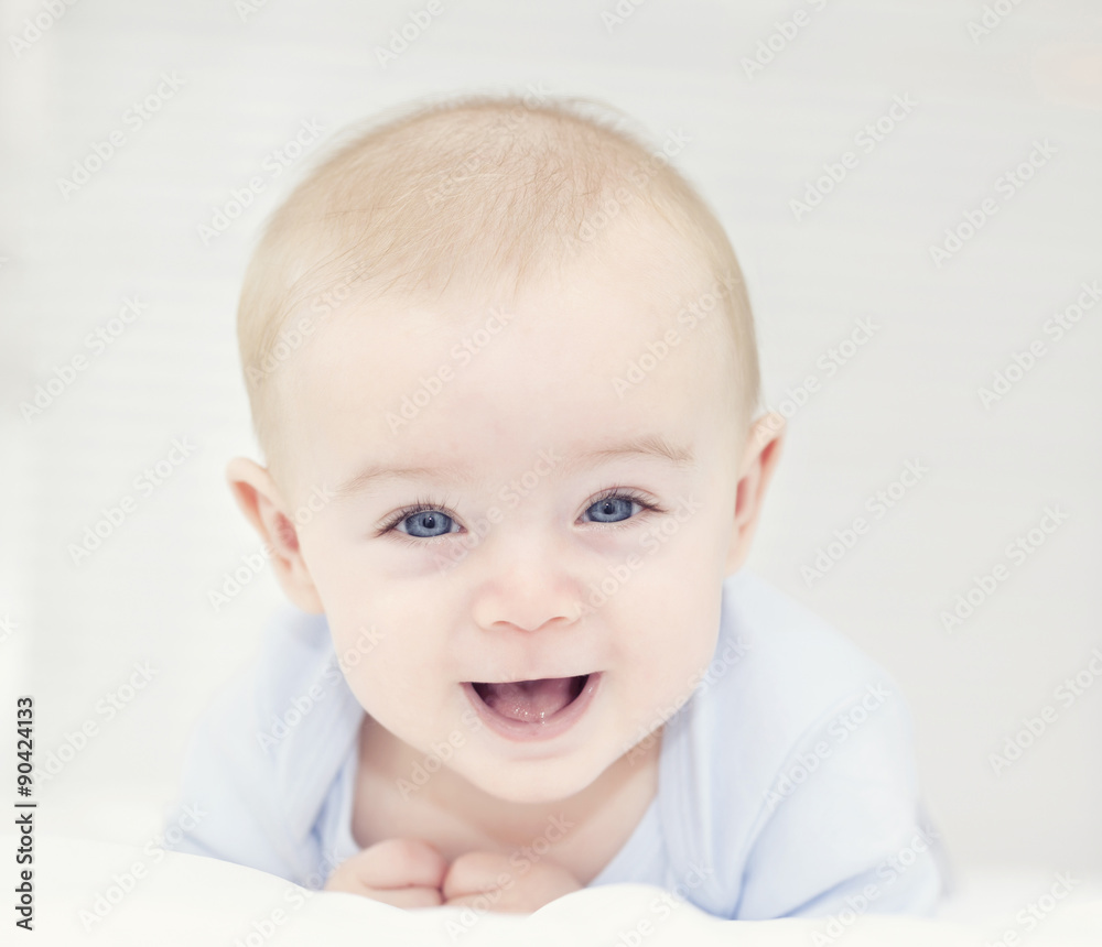 Baby with blue eyes looking to the camera and smiling Baby with blue eyes looking to the camera and smiling