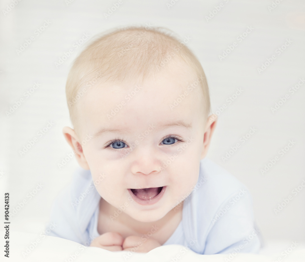 Baby with blue eyes looking to the camera and smiling