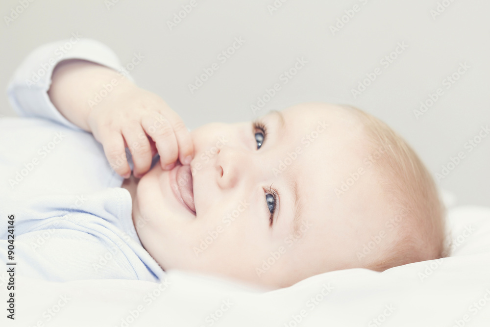 Adorable baby lying in the bed and looking up Adorable baby lying in the bed and looking up