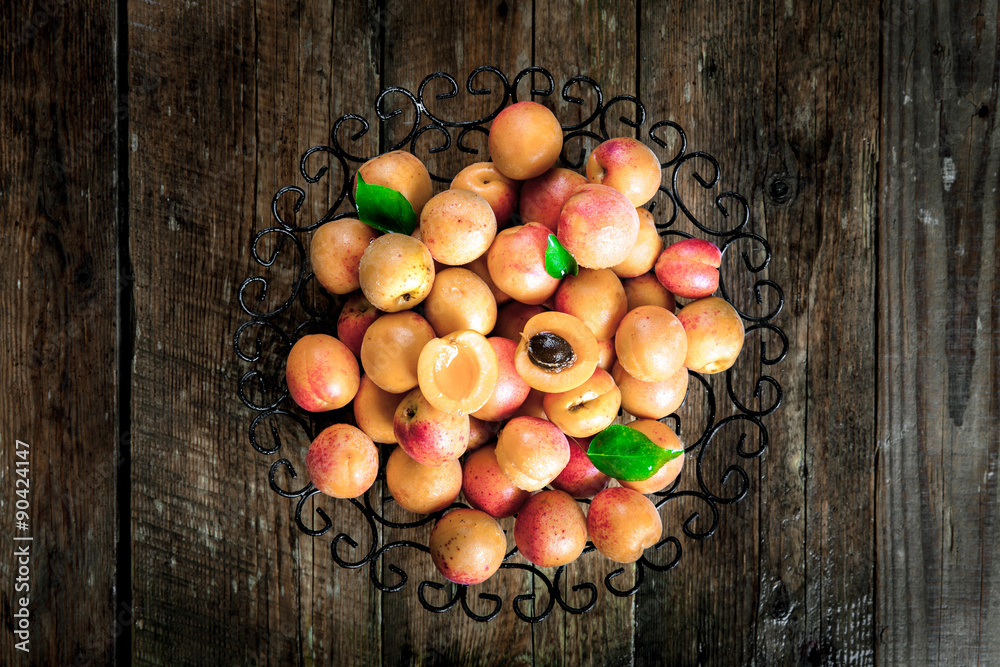 Bowl of harvested apricots.  Fresh apricots on wooden background