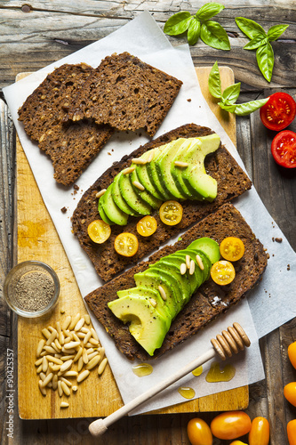 sandwich with rye bread on old wooden table. with avocado and co