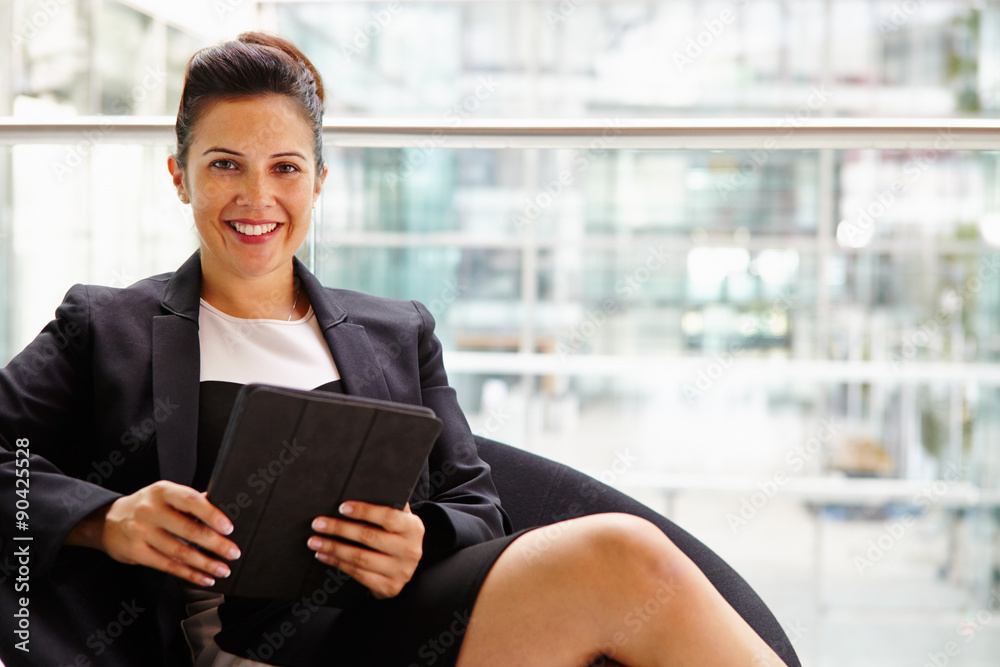Businesswoman holding tablet computer, looking to camera Businesswoman holding tablet computer, looking to camera