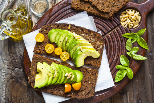 sandwich with rye bread on a board for cutting: avocado, yellow