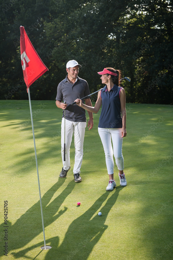 Obraz premium Nice happy couple playing golf during a sunny day.