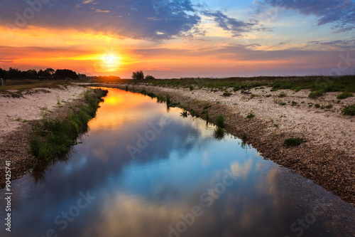 Sunrise with reflection in river landscape