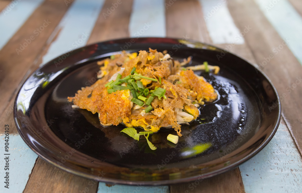 Thai food, Fried mussel with egg and bean sprouts in plate on wo