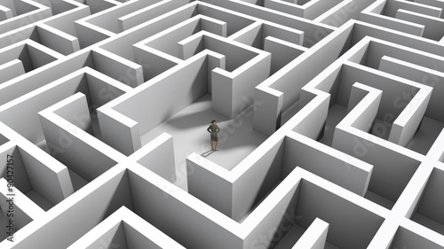 Businesswoman standing in middle of maze photo