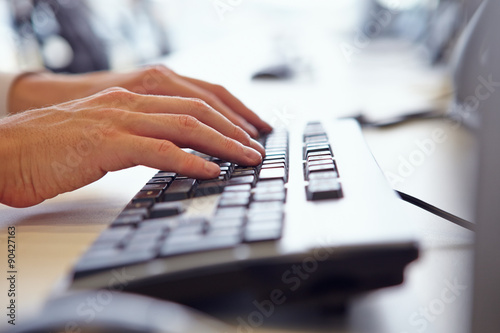 Close up of man?s hands using the keyboard of a computer