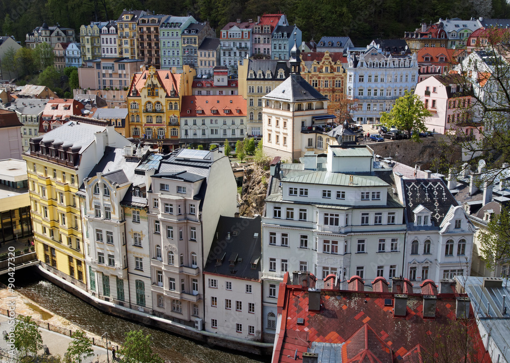 View of the historic town in the wooded valley. Town of Karlovy Vary in the Czech Republic. Old houses with colorful facade. View from above.