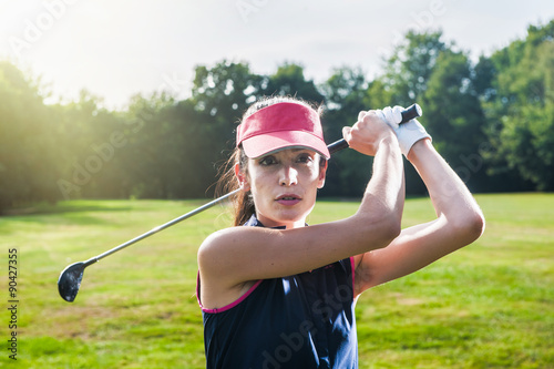 Playing golf, close up of a woman just finishing her swing