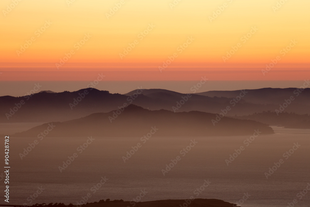 Hazy sunset over Angel Island and the Marin Hills of the Golden-Gate National Recreation Area. Shot from Grizzly Peak, Berkeley Hills, California, USA.