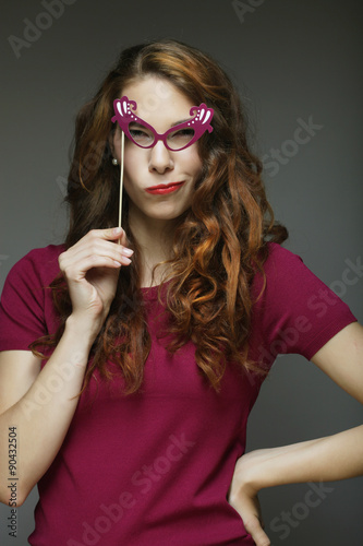 Party image. Playful young women holding a party glasses.