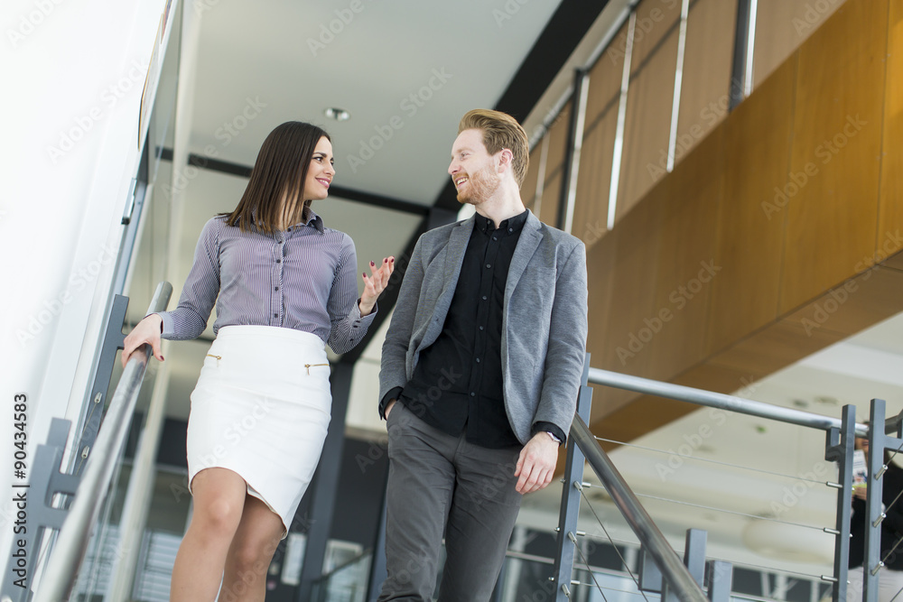 Young couple on the stairs in office Young couple on the stairs in office