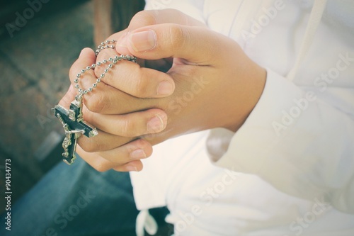 Hands praying with cross