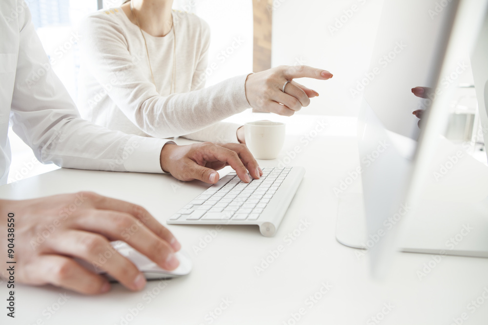 Fototapeta premium Men and women are looking at the computer monitor together