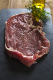 raw meat with rosemary on slate