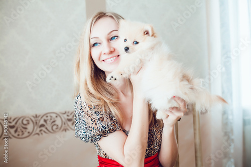 Fototapeta Naklejka Na Ścianę i Meble -  Beautiful Blonde Woman with Her Dog in a Beautiful Interior