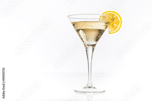 Coppa martini con fetta di limone su sfondo bianco