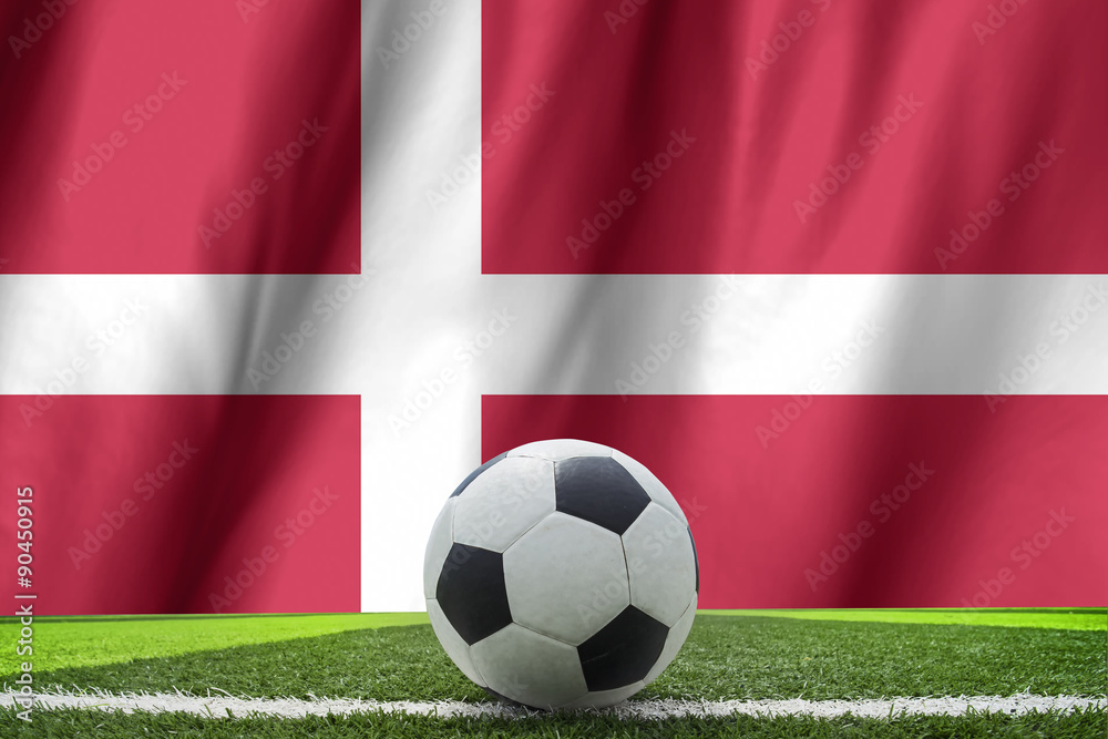 Fototapeta premium Soccer ball and national flag of Denmark lies on the green grass