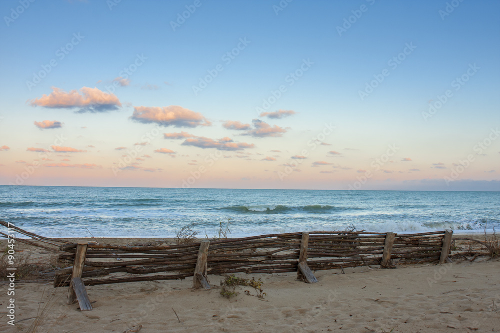 Nuvole rosa , tramonto sul mare. Spiaggia con barriere in legno