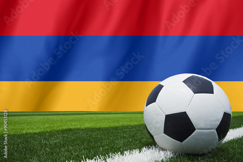 Soccer ball and national flag of Armenia lies on the green grass