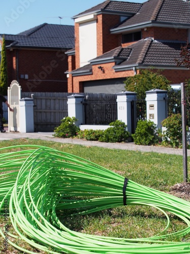 Green fiber optic cable piled in front of residential housing, part of the National Broadband Network roll out, supplying homes with high speed broadband, Melbourne, Australia 2015