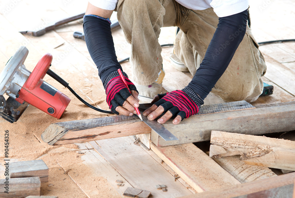 Carpenter man measuring plank of wood for Home Building