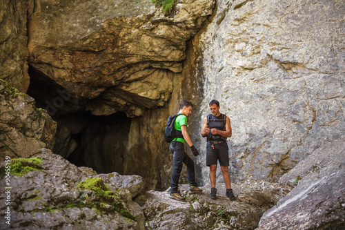 Hikers standing at the entrance of a cave