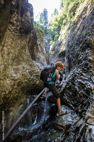Woman backpacker going down in a gorge