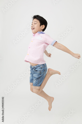 Happy asian boy is jumping at studio.