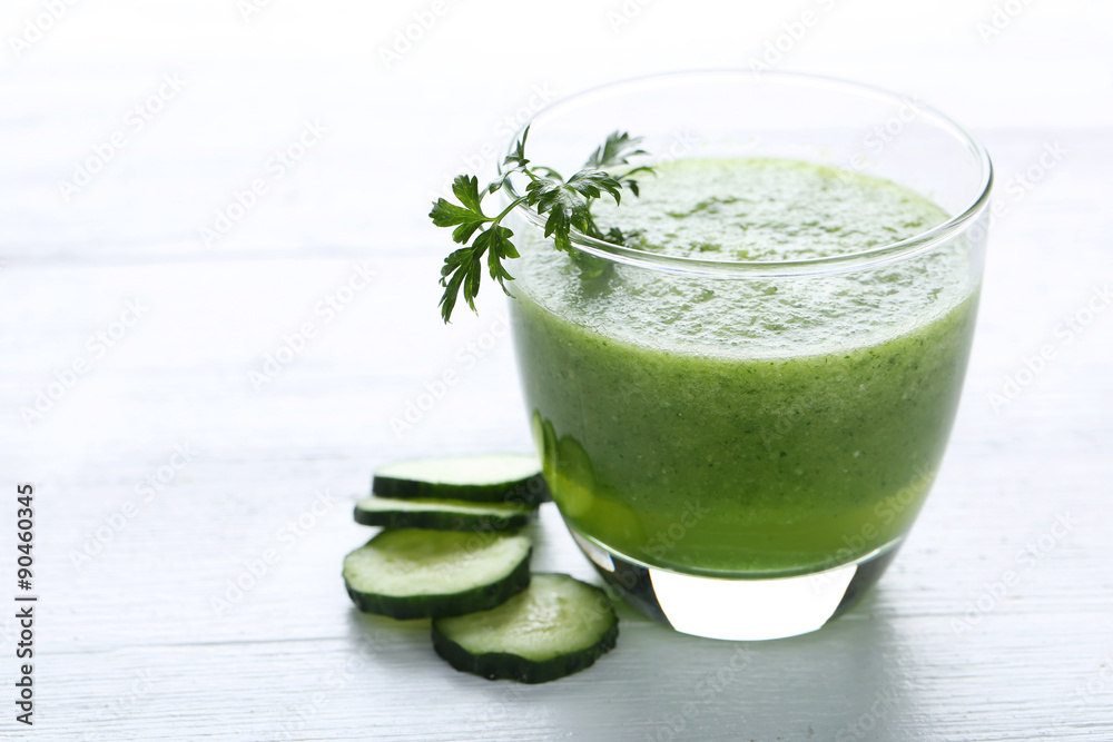 Glass of fresh cucumber juice on white wooden table Glass of fresh cucumber juice on white wooden table