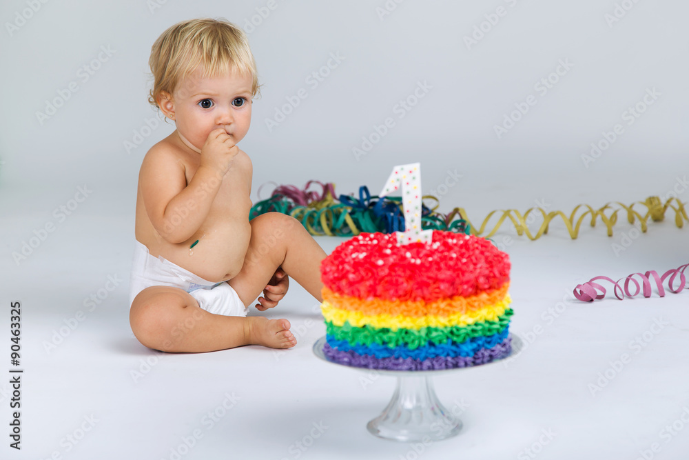 Baby girl celebrating her first bithday with gourmet cake and ba Baby girl celebrating her first bithday with gourmet cake and ba