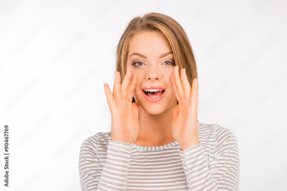 Great news! Cheerful young woman holding hand near mouth Great news! Cheerful young woman holding hand near mouth