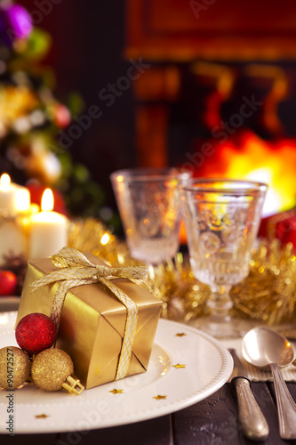 Christmas table with a fireplace in the background.