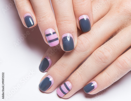 Beautiful women s manicure with gray and pink polish on the