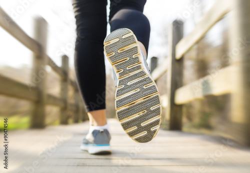 фотографія Woman jogging across a country bridge in the morning
