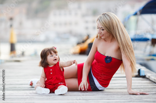 Happy young mother with a young daughter near Yacht Club