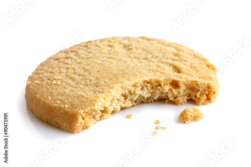 Single round shortbread biscuit with crumbs and bite missing. In