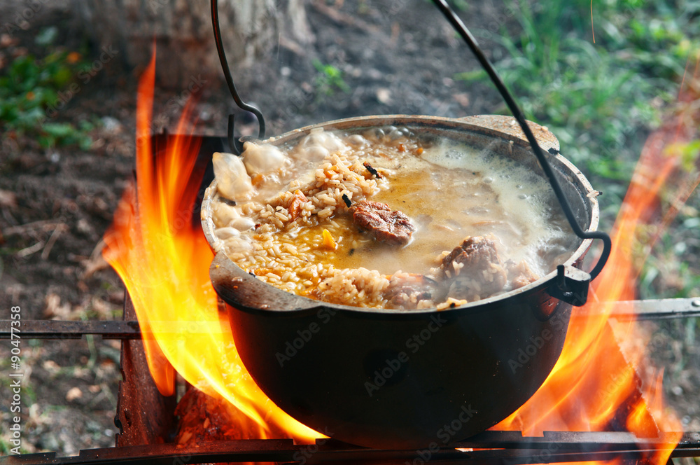 Cooking pilaf in a casserole on the fire close up Cooking pilaf in a casserole on the fire close up