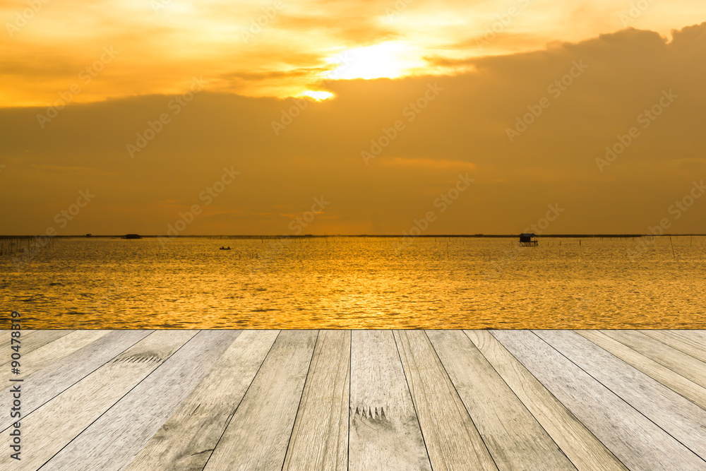perspective wood plank floor or walk way on over blur sea above sunset background