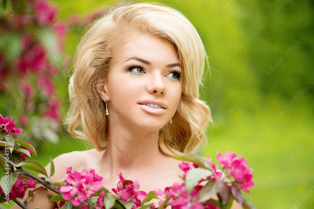 Young spring fashion woman. Trendy girl in the flowering trees i Young spring fashion woman. Trendy girl in the flowering trees i