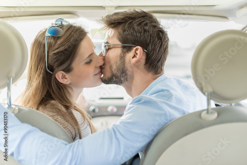 rear view, a lovely couple kissing in a car