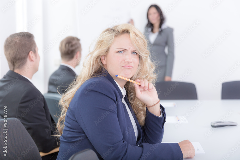 Junge Frau im Blazer versteht etwas nicht im Seminar Junge Frau im Blazer versteht etwas nicht im Seminar