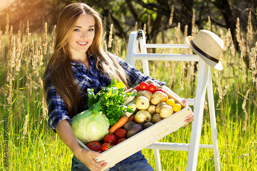 Счастливая молодая девушка с овощами в ящике 