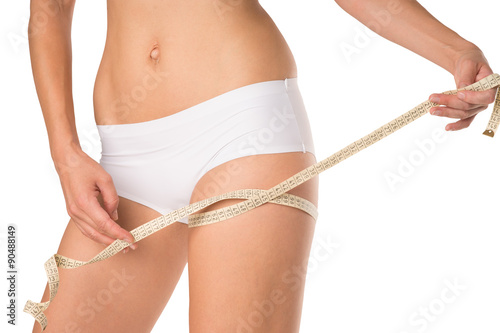 waist circumference   Woman measuring her thigh circumference