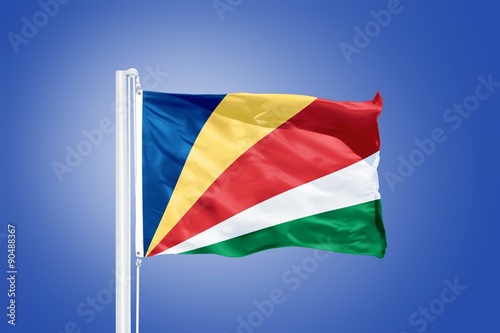 Flag of Seychelles flying against a blue sky