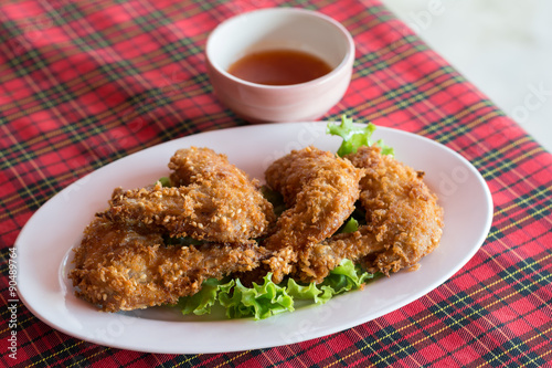 A plate of fresh, hot, crispy fried chicken on a red plaid towel