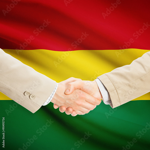 Businessmen handshake with flag on background - Bolivia