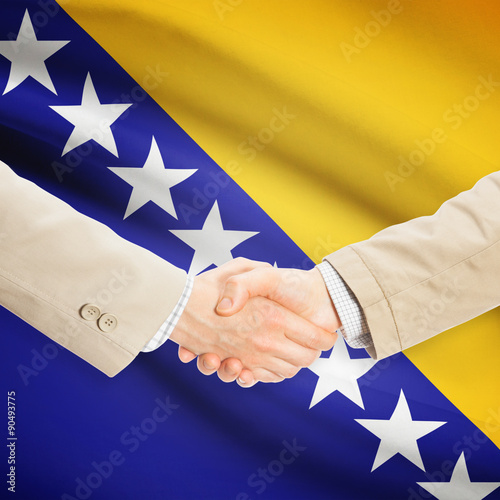 Businessmen handshake with flag on background - Bosnia and Herze